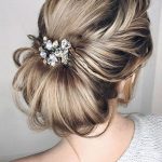 Picture Of a messy and textural low chignon hairstyle with a light .