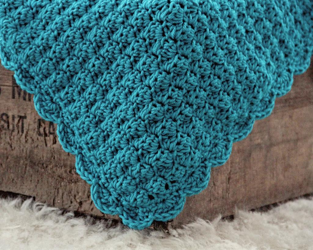 Best Crochet Blanket Patterns blue blanket draped over wooden box bfovdmf
