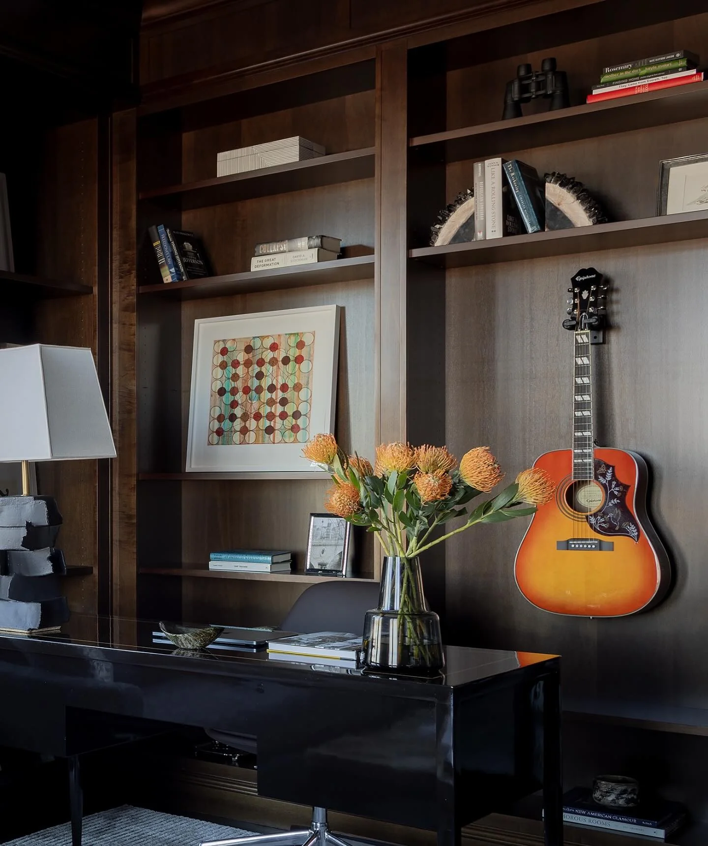 Glossy Black Desk Paired with Walnut Bookcases and Artistic Touches