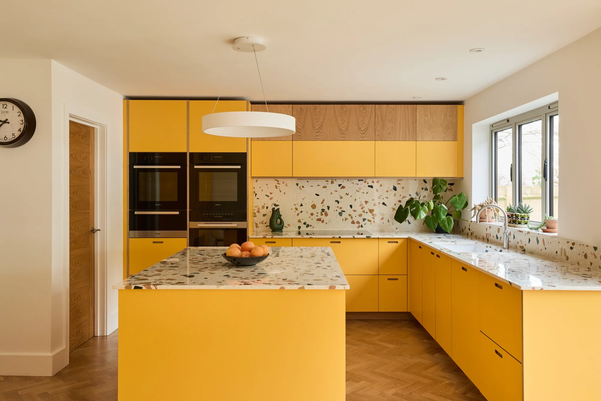 Minimalist Elegance: Ochre Cabinets with Terrazzo Accents (Yellow Kitchen Ideas)