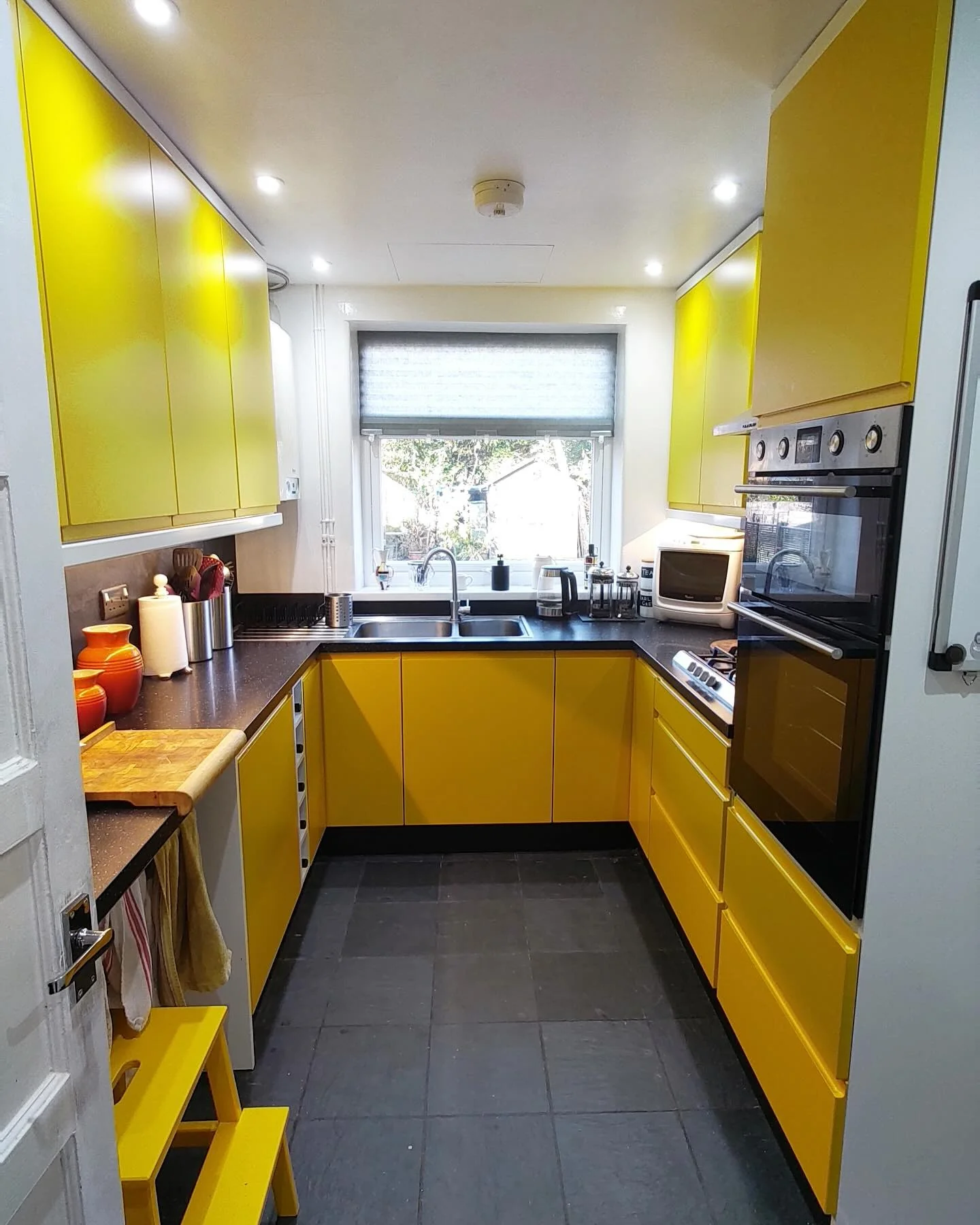 Urban Chic: Yellow Cabinets with Matte Black Stone Counters (Yellow Kitchen Ideas)