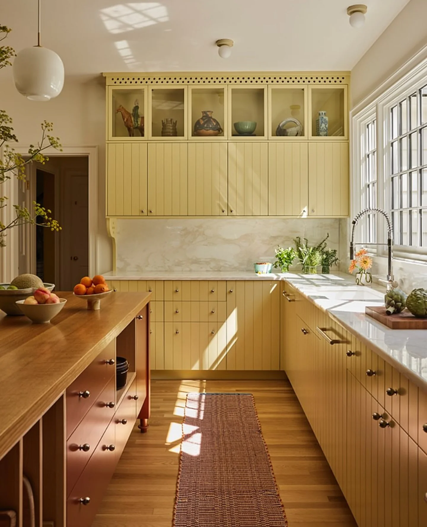 Soft Buttermilk Paneling with Clay Island and Marble Details (Yellow Kitchen Ideas)