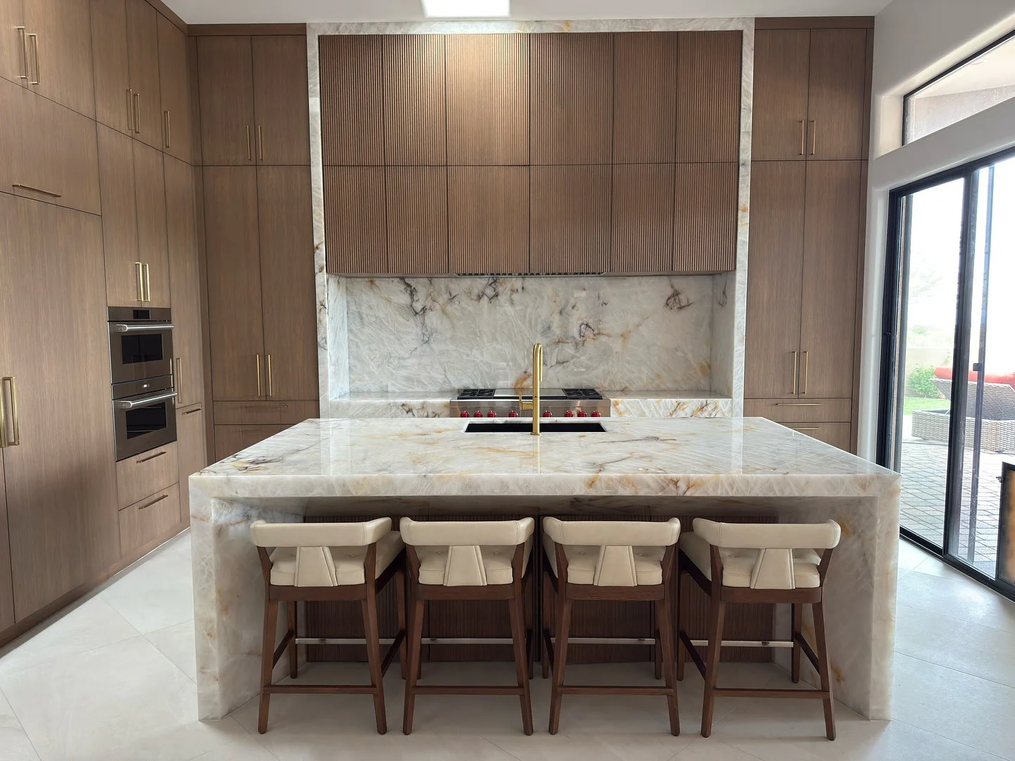 Monochrome kitchen with walnut cabinets and marble