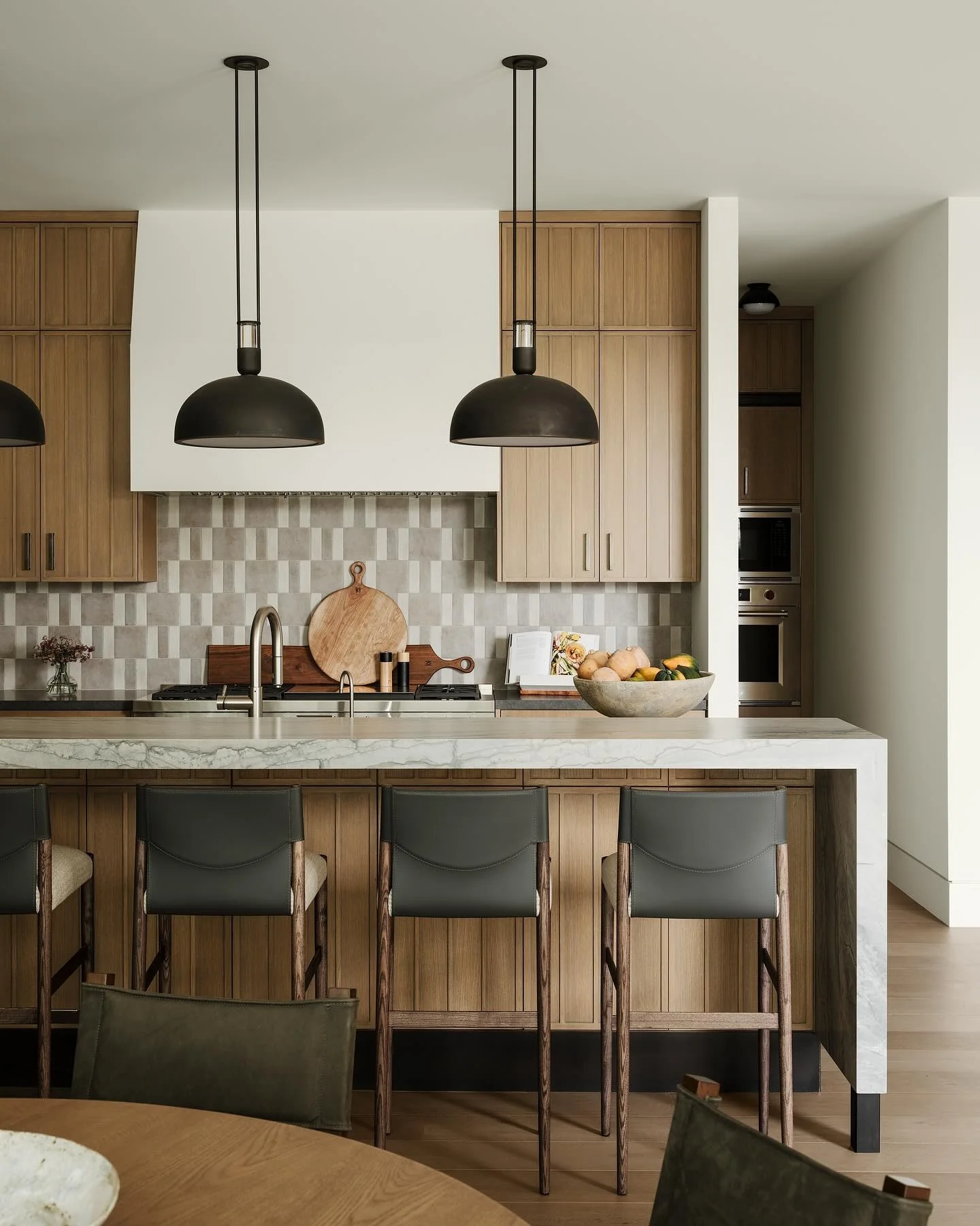 Kitchen with vertical wood panels and geometric backsplash