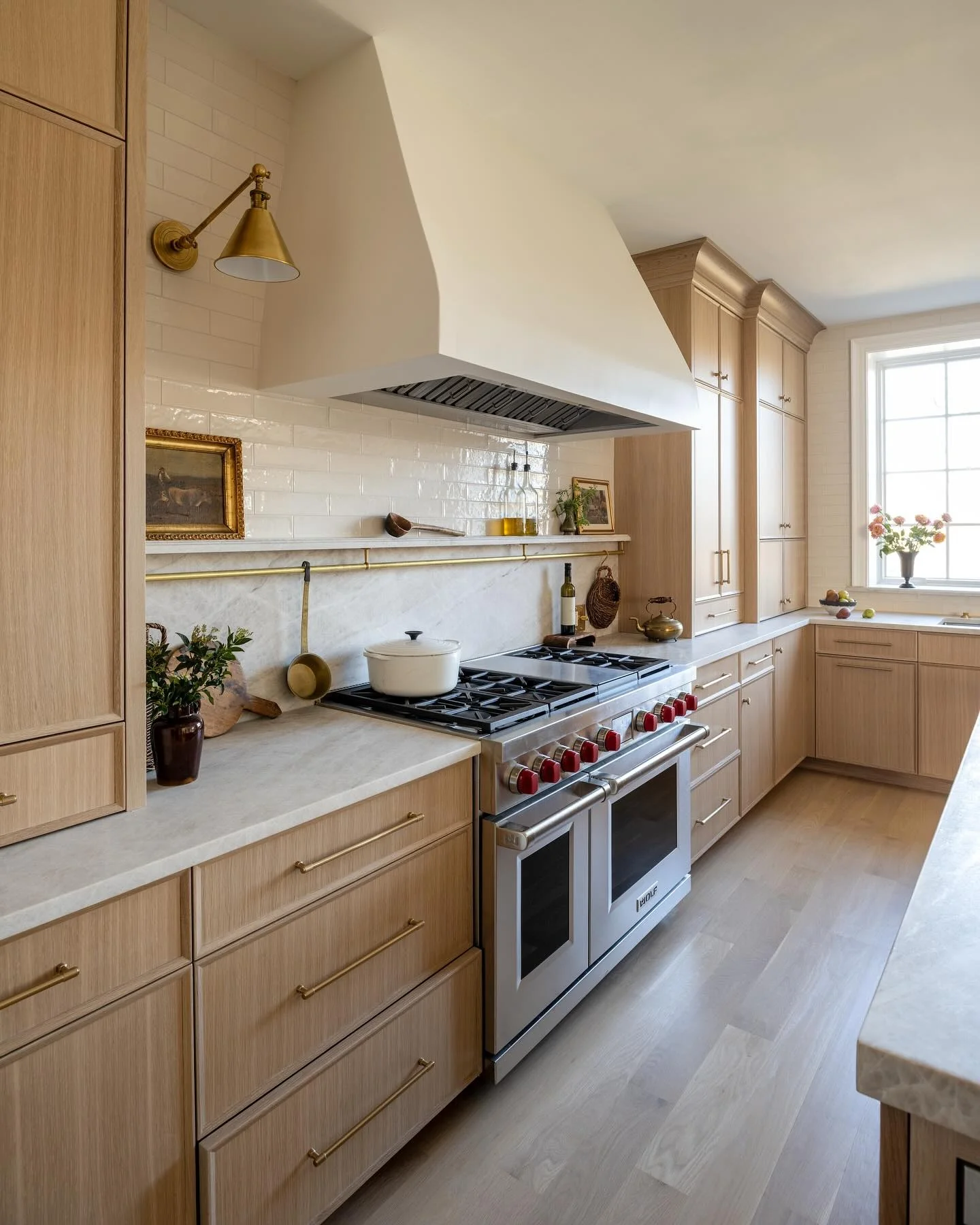 Kitchen with light oak cabinets and marble counters