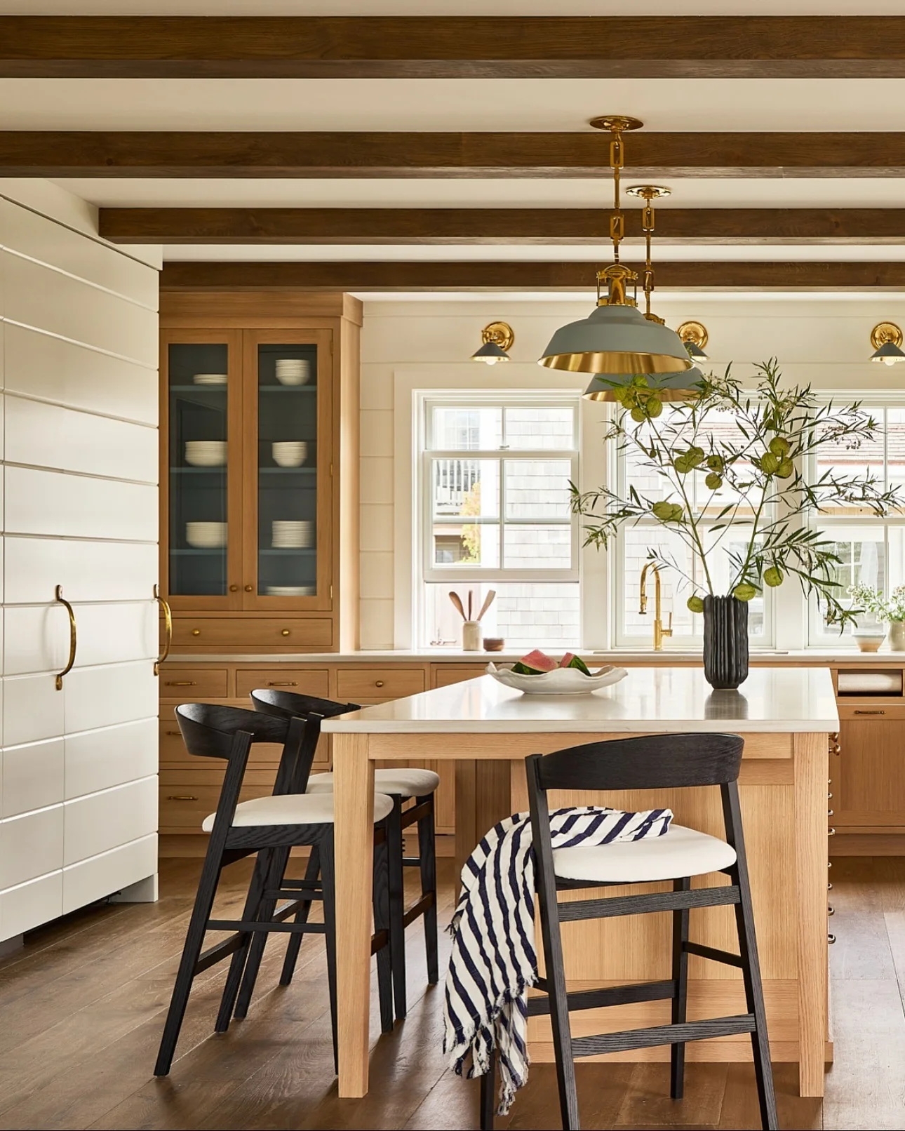 Coastal kitchen with pale oak cabinets and matte brass hardware