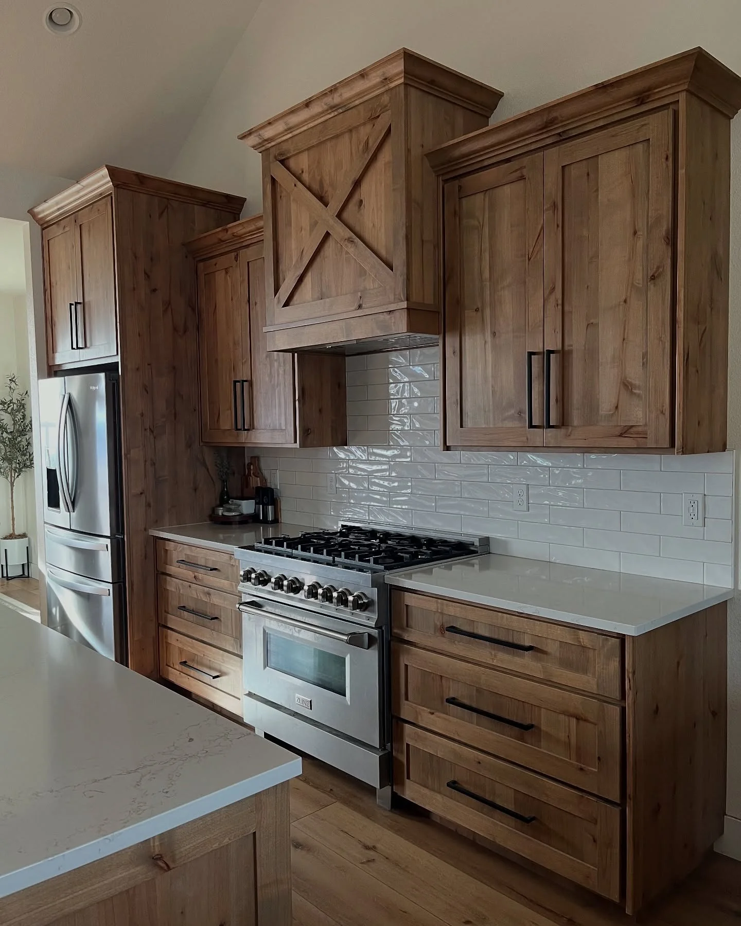 Farmhouse kitchen with knotty pine cabinets and white counters
