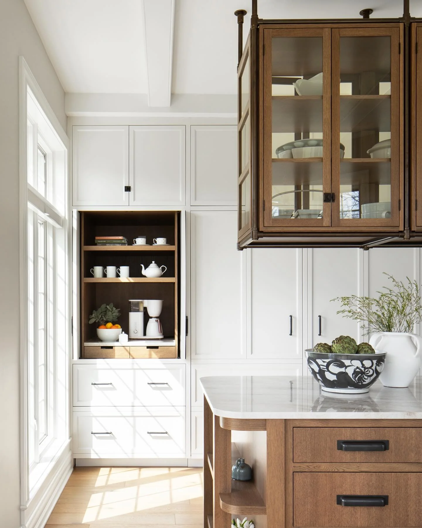 Kitchen with glass suspended cabinets and wood paneling