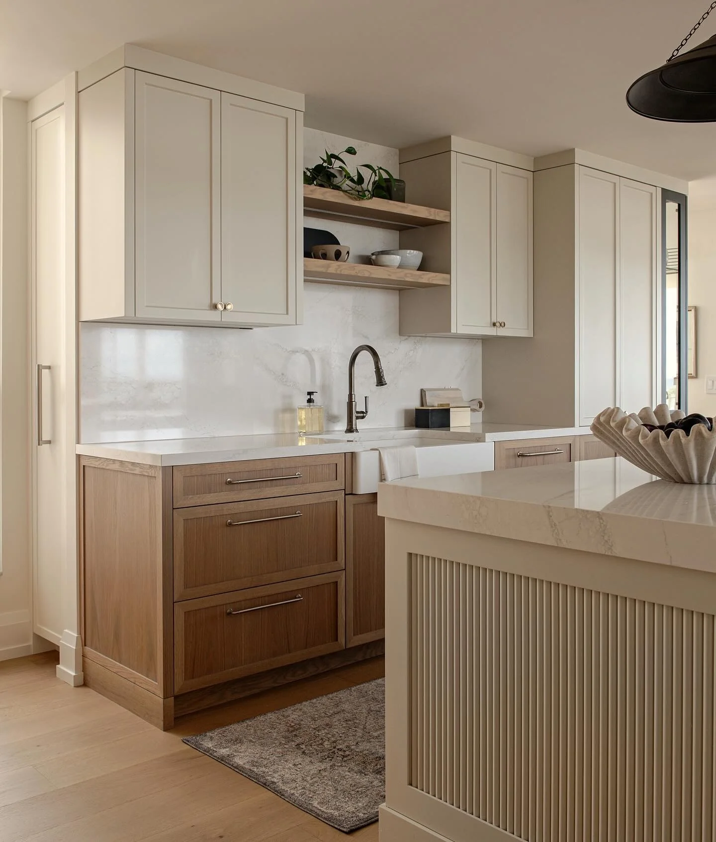 Two-tone kitchen with cream upper and oak base cabinets