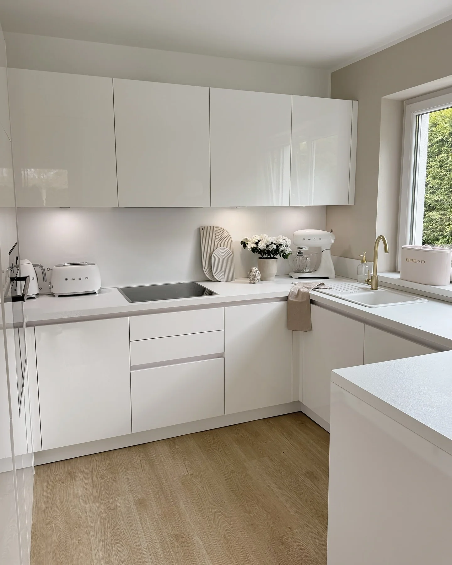 Glossy White Minimalist Kitchen with Oak Flooring