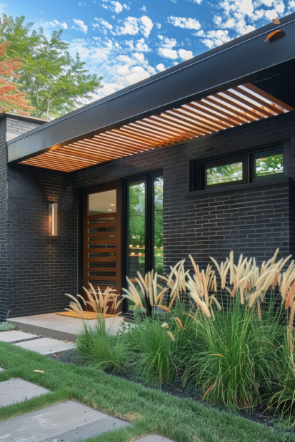 Black brick home entrance with wooden awning and grasses