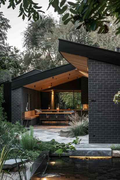 Black brick pavilion with glass walls and pond