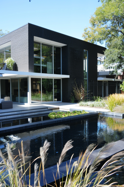 Modern black brick home with water feature